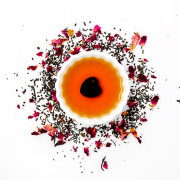 a cup of tea with a heart shaped item inside of it surrounded by tea leaves