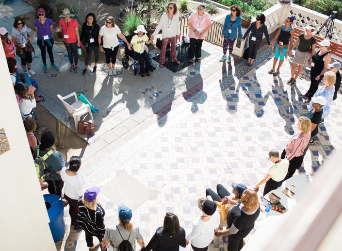a group of women holding hands while standing on a blue and white checkered floor